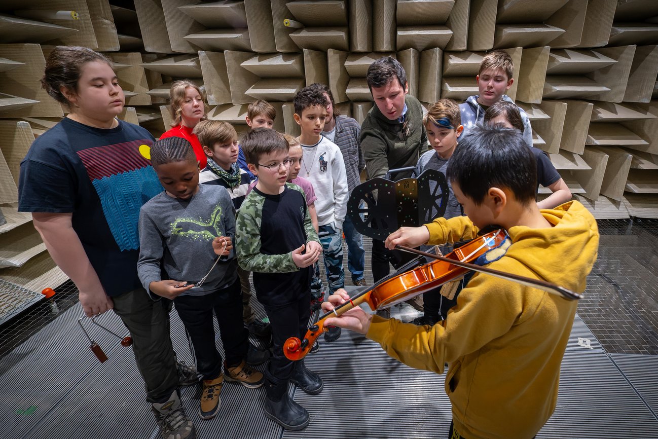 Enfants qui écoutent un de leurs camarade jouer d'un instrument