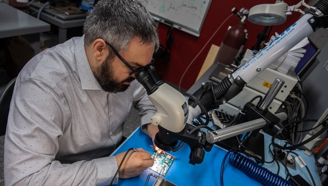 Jonathan Bouchard qui regarde à travers un microscope