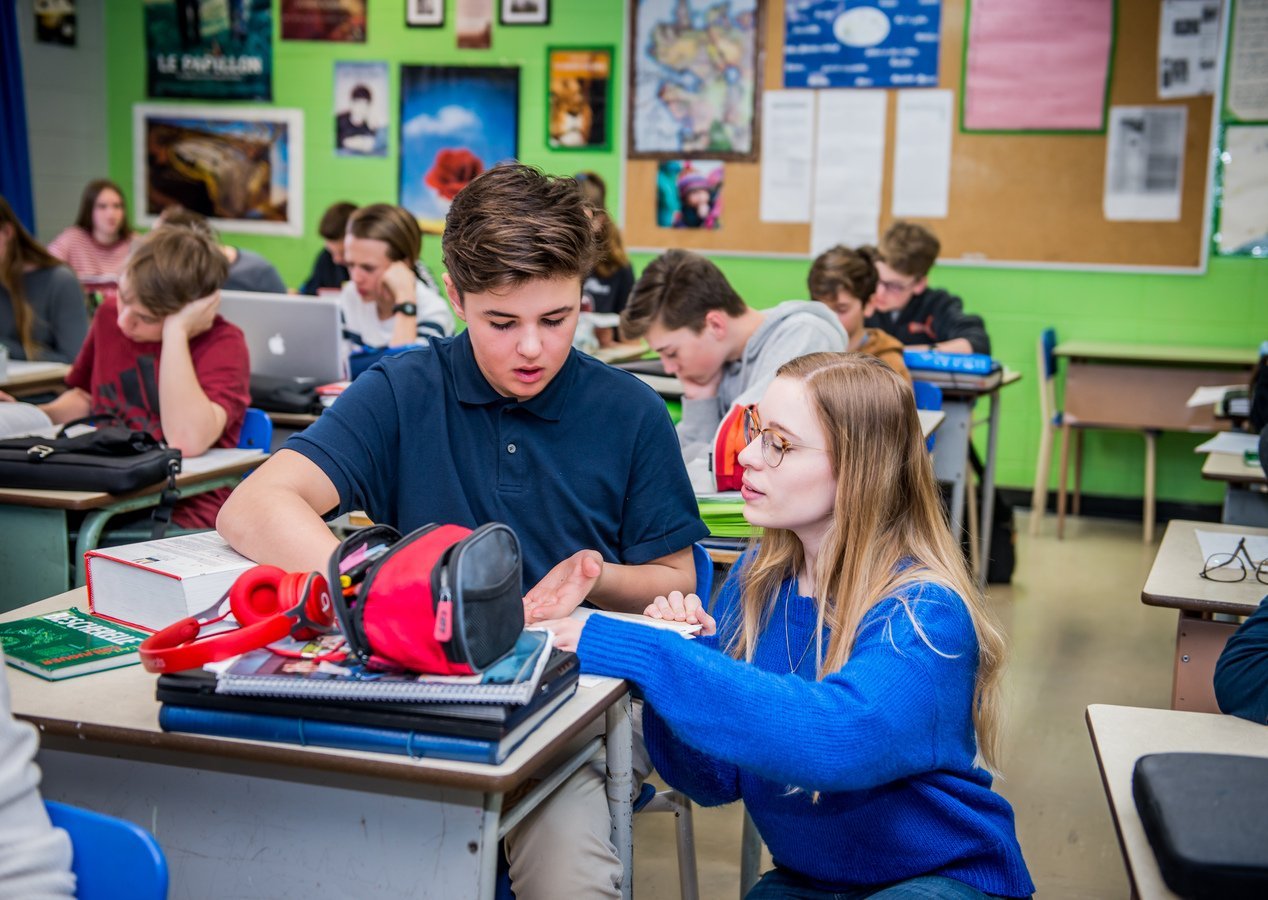 Enseignante accompagnant un élève en classe