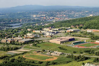 Vue aérienne du campus et de ses installations sportives extérieures avec le mont Orford à l'horizon