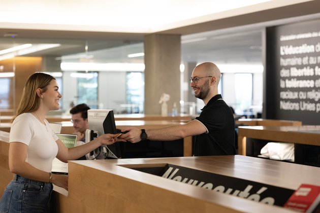 Deux personnes au comptoir de prêt d'une biblithèque
