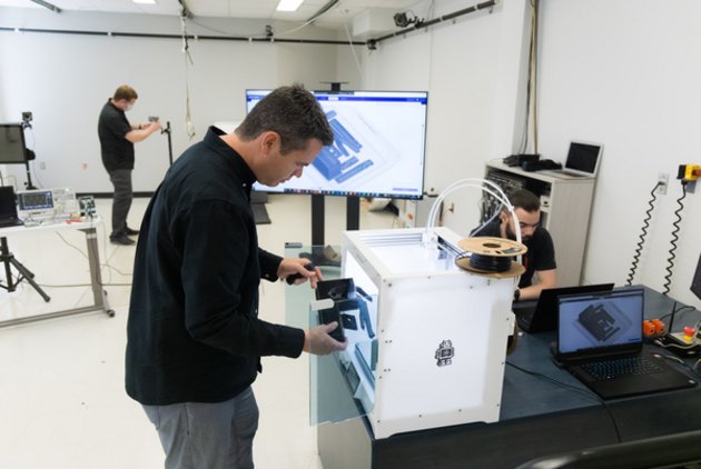Un homme qui manipule un objet imprimé à partir d'une imprimante 3D.