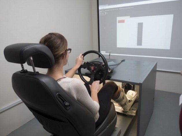 Photo d'une femme qui utilise le simulateur de conduite automobile.
