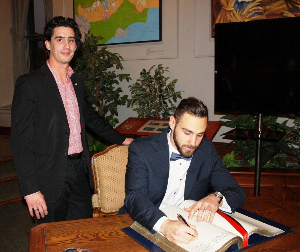 Le conseiller municipal Vincent Boutin et le quart-arrière du Vert & Or Jérémi Roch, signant le livre d'honneur de la Ville de Sherbrooke, le 25 novembre dernier.