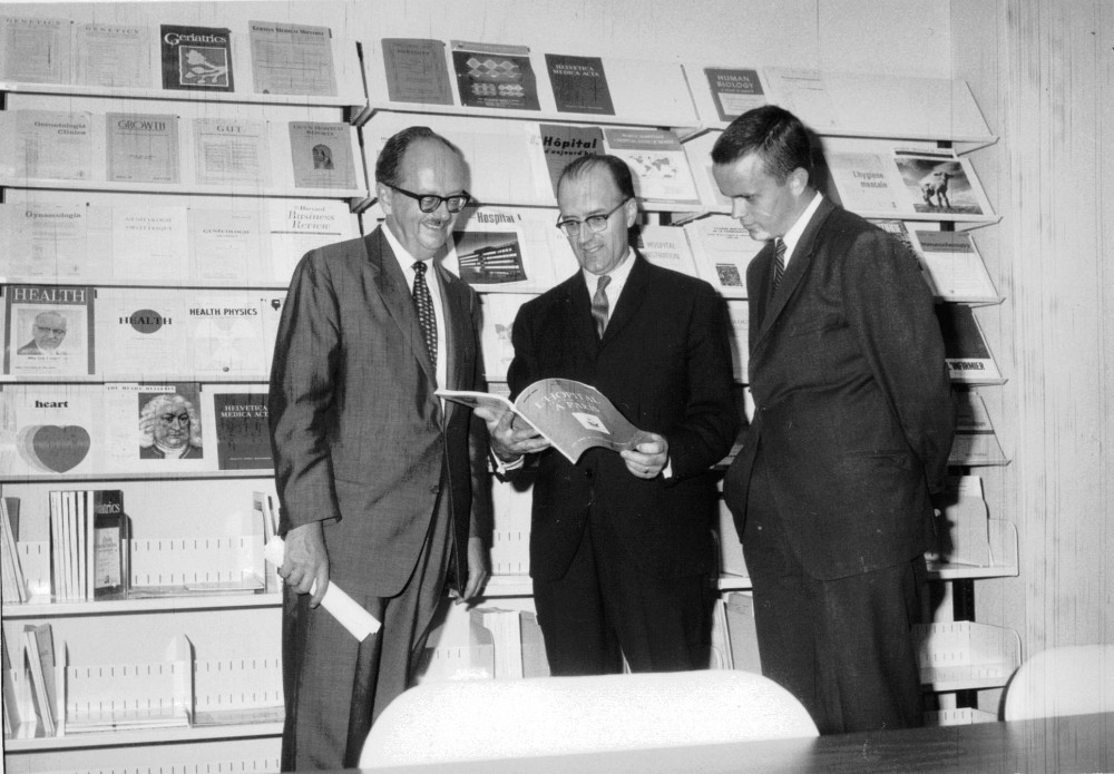 Bibliothèque de la Faculté de médecine. De gauche à droite : Pr Jean-Marie Beauregard, vice-doyen de la Faculté et président de la bibliothèque, M. Germain Bélisle, bibliothécaire en chef et M. Daniel Blouin, étudiant, 6 septembre 1966.