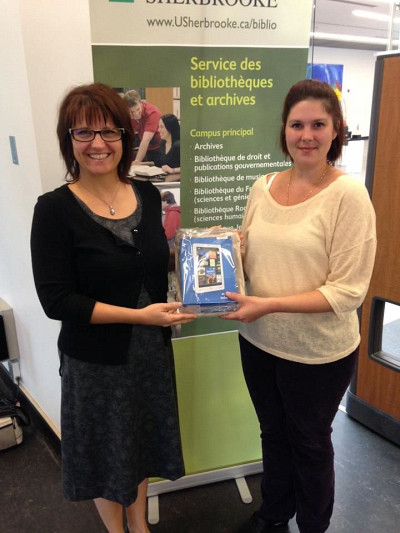L'étudiante Rachel Cuerrier gagnante d'une liseuse Kobo. Nathalie St-Jacques, bibliothécaire au Campus de Longueuil remet le prix.