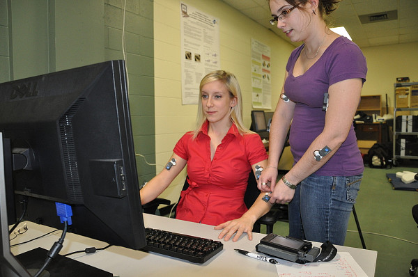À l'aide d'électrodes, les stagiaires mesurent l'activité musculaire en cours lors du travail à un poste informatique.