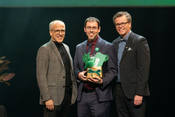 Daniel Garneau, accompagné du recteur, Pierre Cossette, et de l'animateur de la soirée et vice-recteur aux ressources humaines, Patrik Doucet.