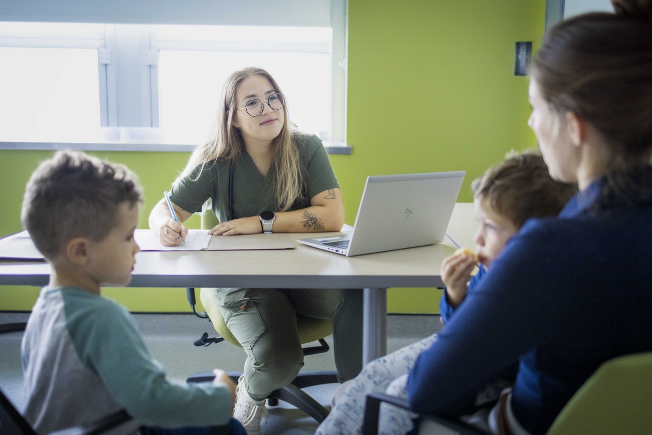 Une infirmière praticienne spécialisée (IPS) discute avec une patiente et ses enfants