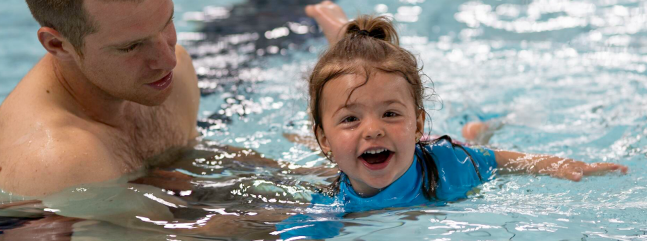 Parent et enfant jouant dans la piscine